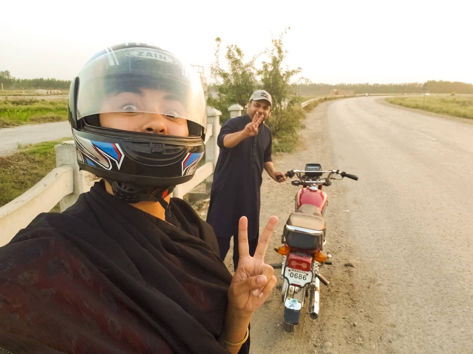 Motorbiking as a woman in Pakistan - Selfie with man and motorbike in Khyber Pakhtunkhwa - Lost With Purpose travel blog