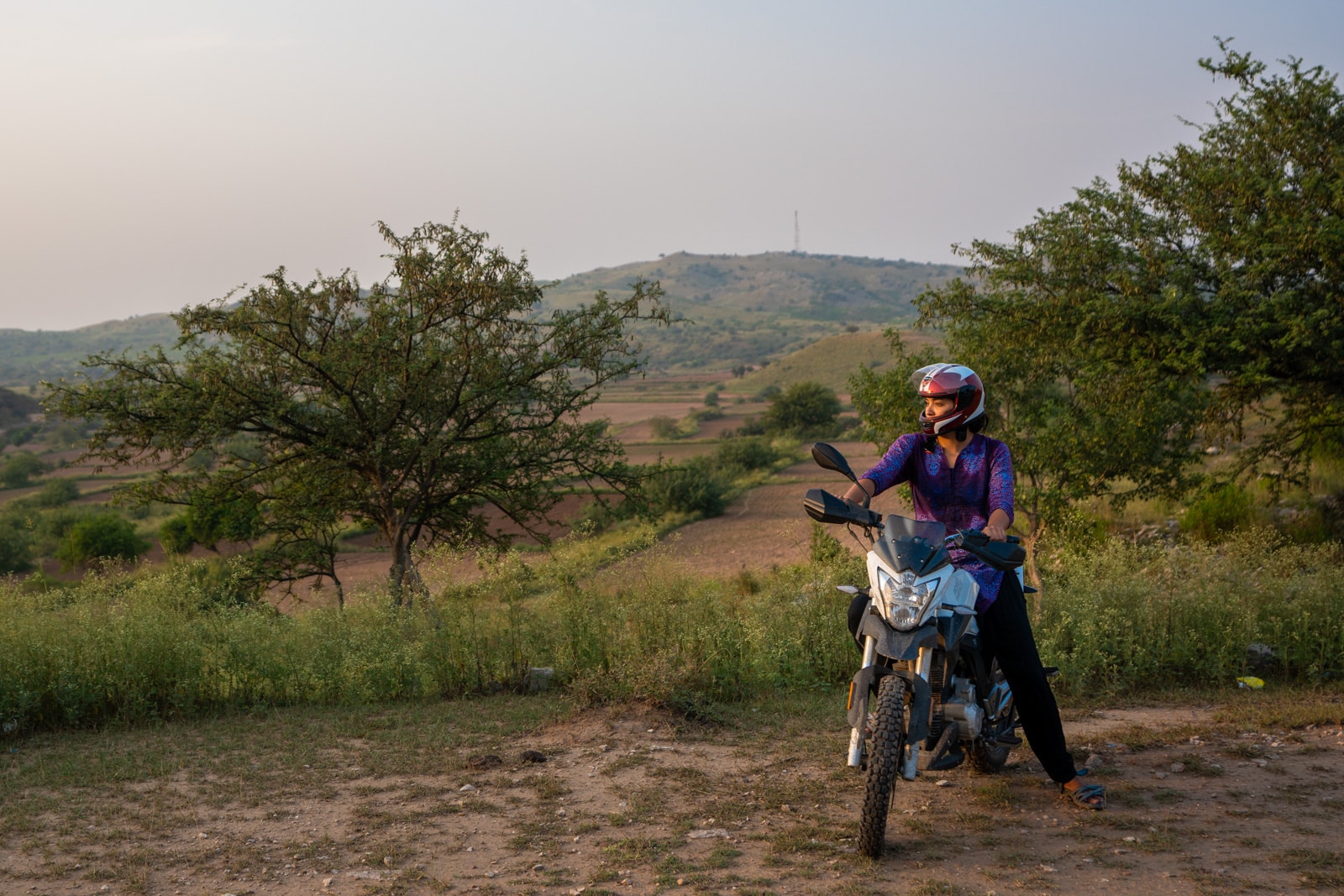 Learning to motorbike as a woman in Pakistan - Alex on a motorbike during sunset in Punjab - Lost With Purpose travel blog