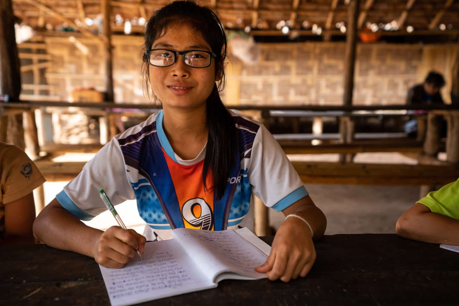 OneSight eye care clinic on the Thailand-Myanmar border - Student with a workbook and glasses - Lost With Purpose travel blog