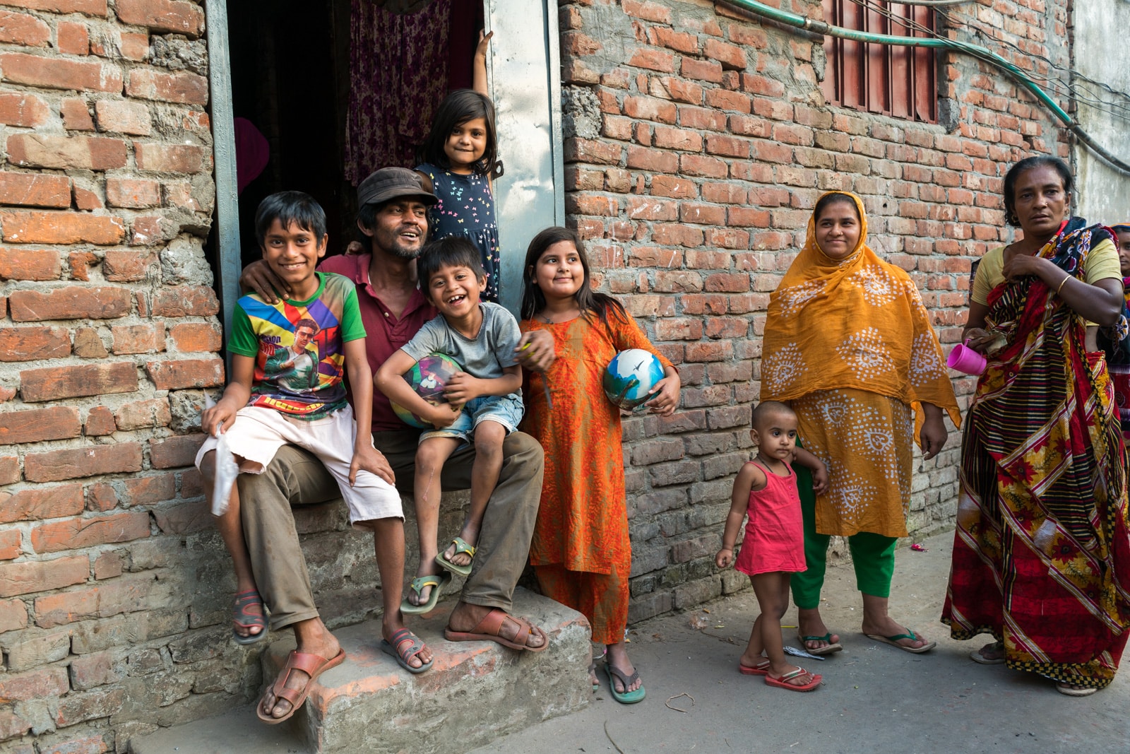 Reflections - Family sitting outside their home on the outskirts of Dhaka, Bangladesh - Lost With Purpose travel blog