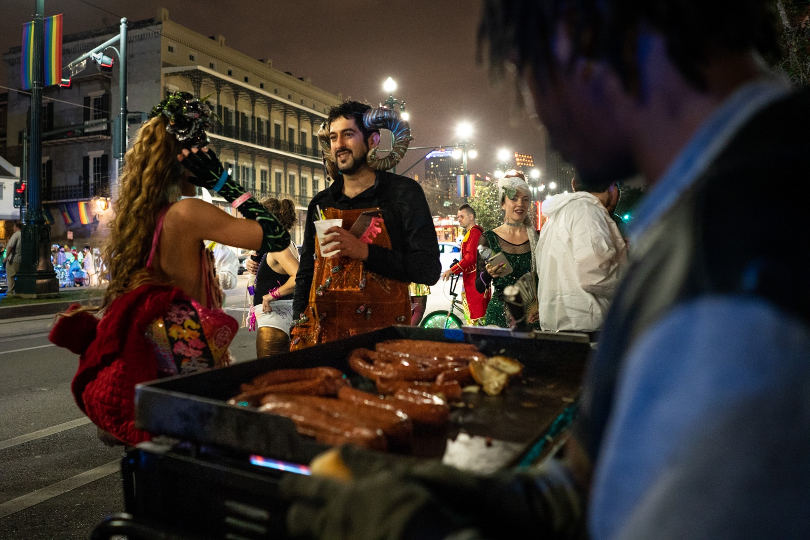 People in costume ordering street food in New Orleans, LA