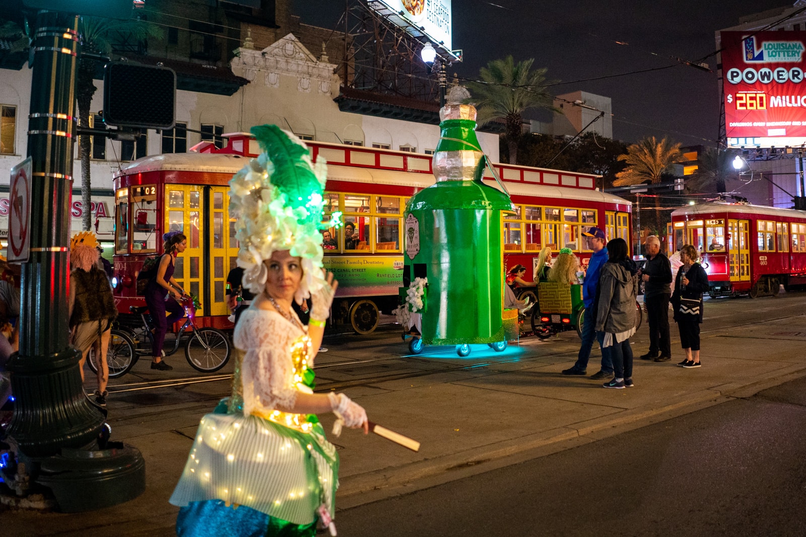 Paraders and floats exiting the parade next to a New Orleans street car