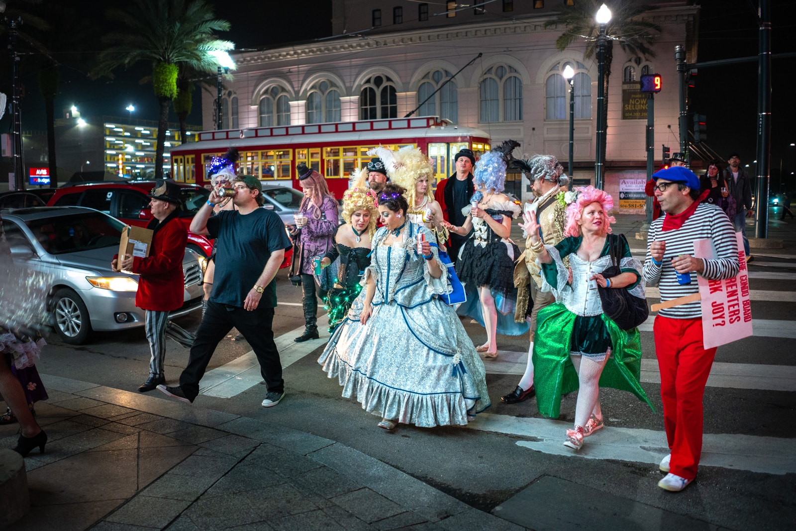 People in Mardi Gras parade costumes walking on the streets of New Orleans after the Krewe Boheme parade