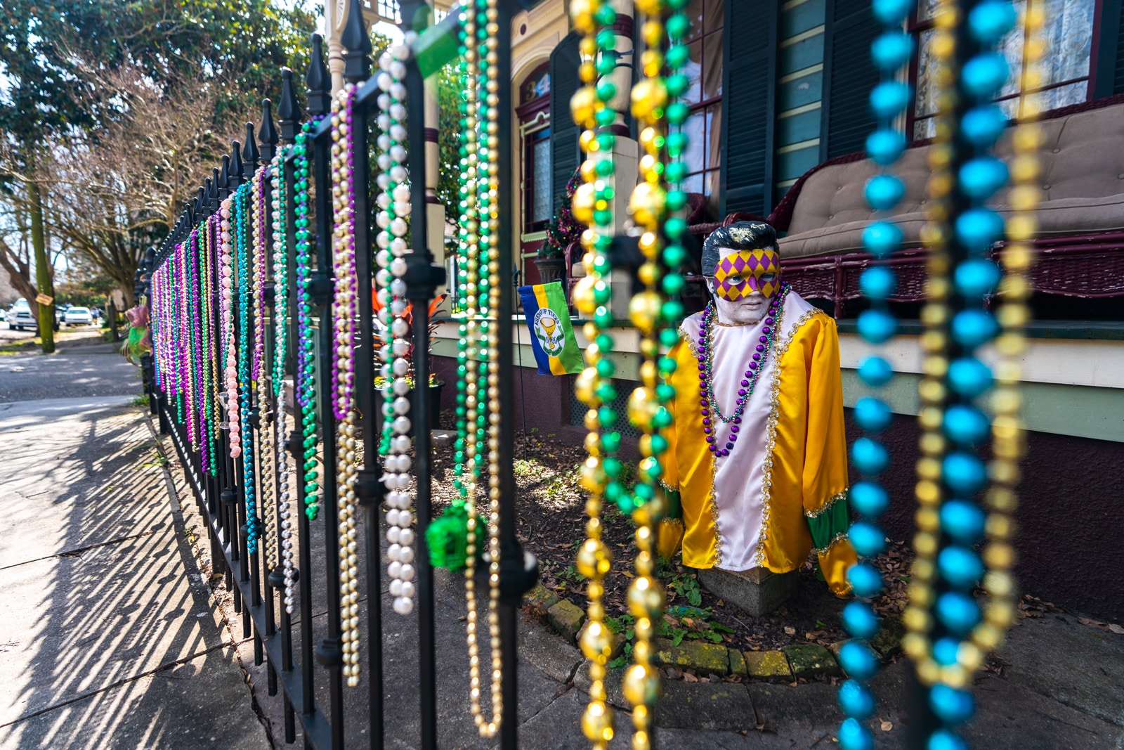 Mardi Gras beads on a fence with an Elvis statue in Algiers, near New Orleans