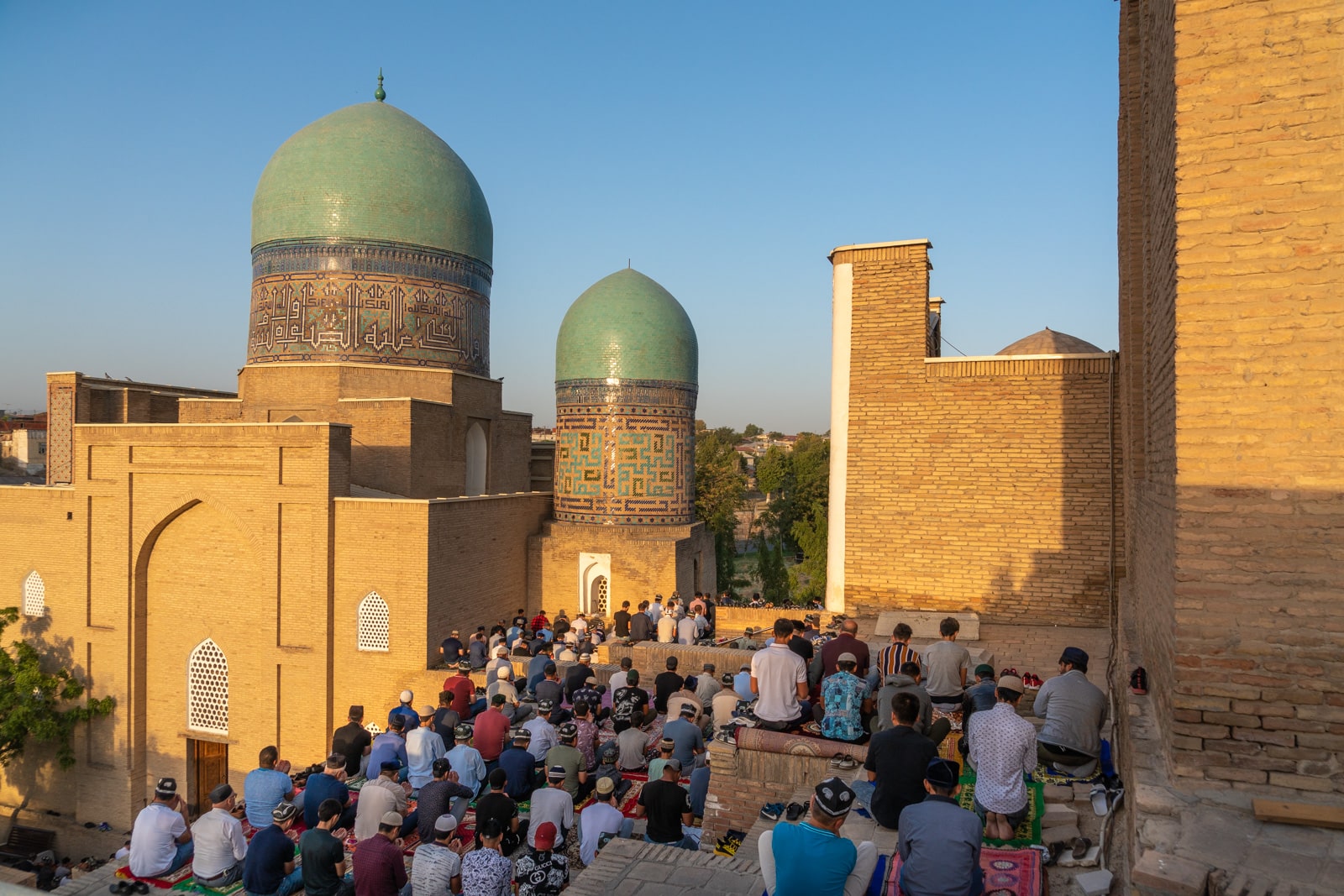 Men praying for Eid outside the Shah-i-Zinda necropolis in Samarkand, Uzbekistan