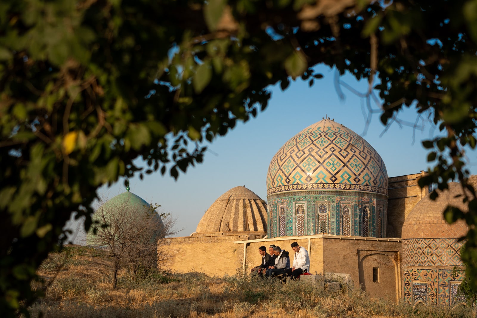 Men praying outside the Shah-i-Zinda necropolis in Samarkand, Uzbekistan