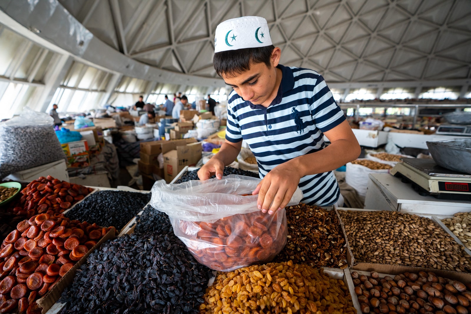 A boy selling dried fruits in Chorsu bazaar, Tashkent, Uzbekistan