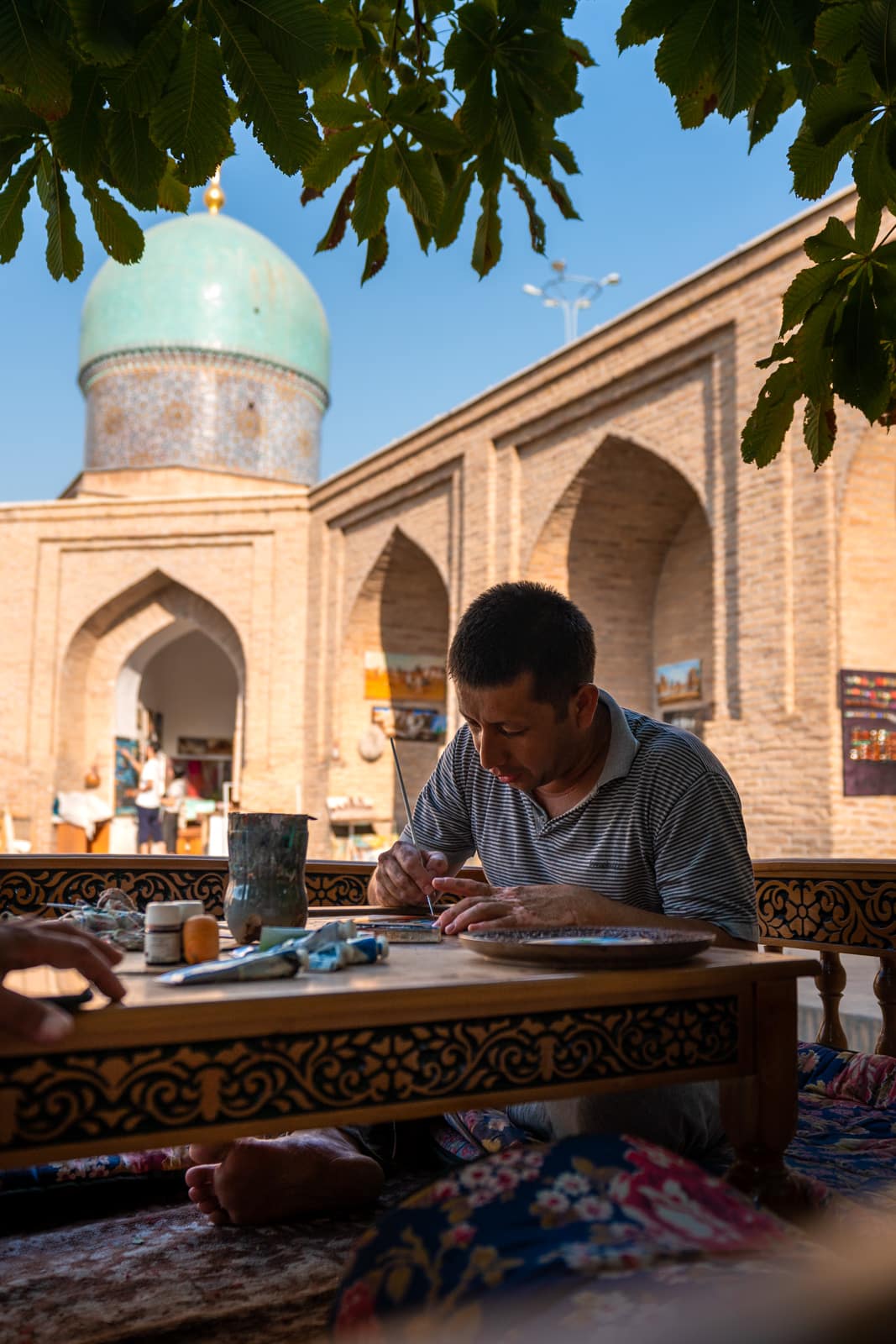 Artisan painting a plate in the Khast Imam complex