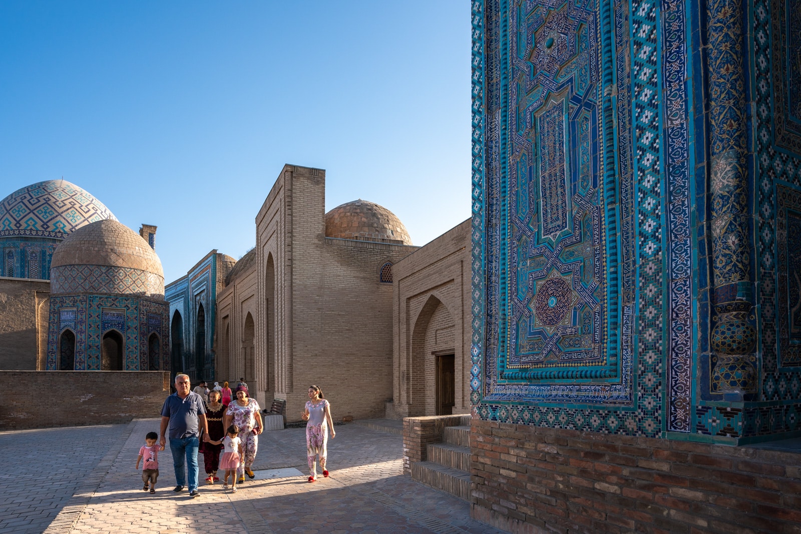 Family walking in evening at the Shah-i-Zinda necropolis in Samarkand, Uzbekistan