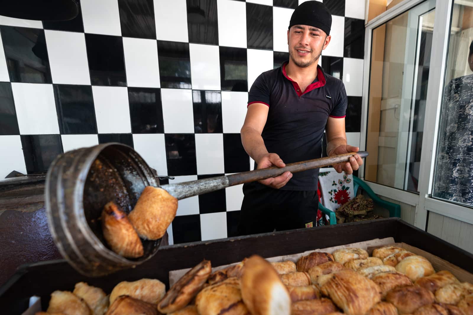 Man cooking tandoori samsa in Panjakent, Tajikistan