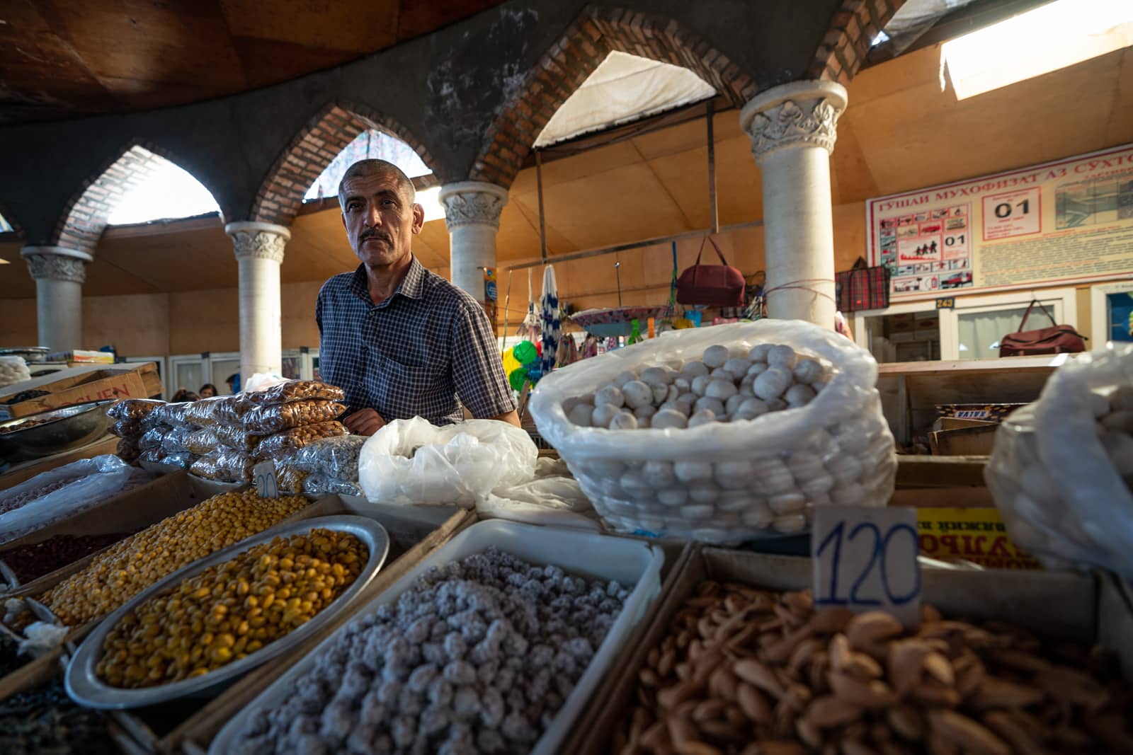 Man selling dried fruits and nuts in the Panjakent Bazaar in Tajikistan