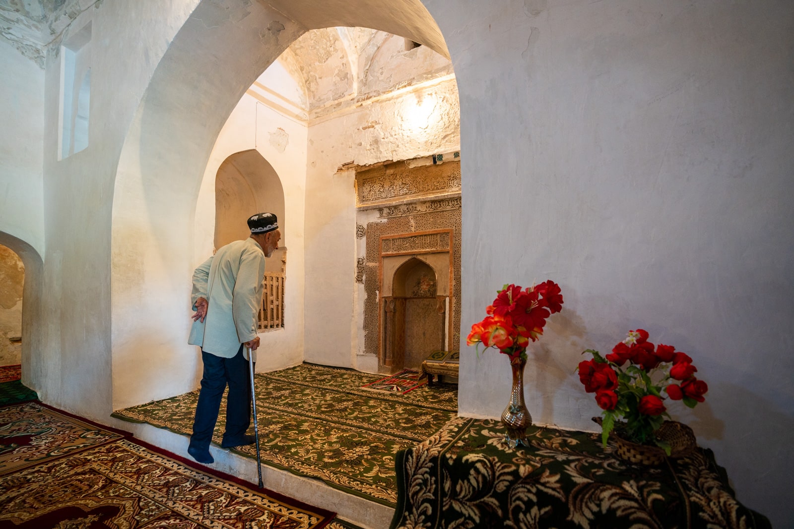 Caretaker walking in mausoleum of Muhammad Bashoro in Western Tajikistan