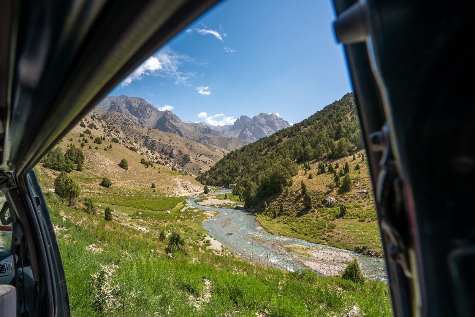 View from van window of Tajikistan's Fann Mountains as travelers drive overland