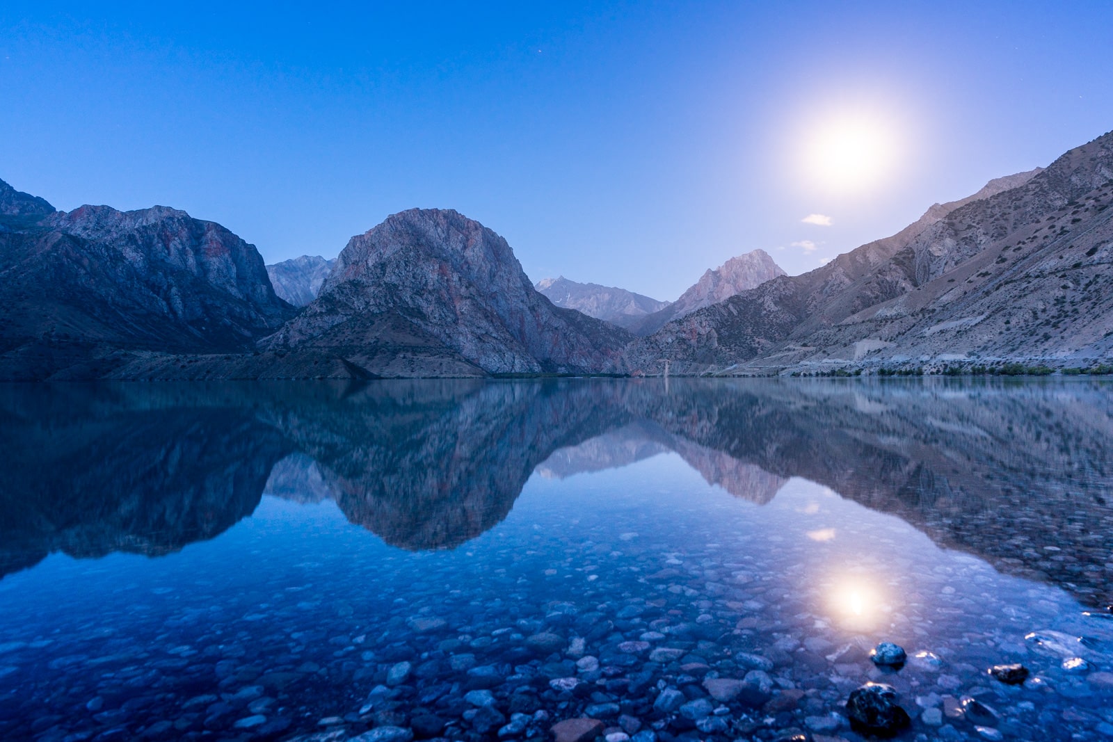 Blue hour and moon over Iskanderkul Lake in Tajikistan