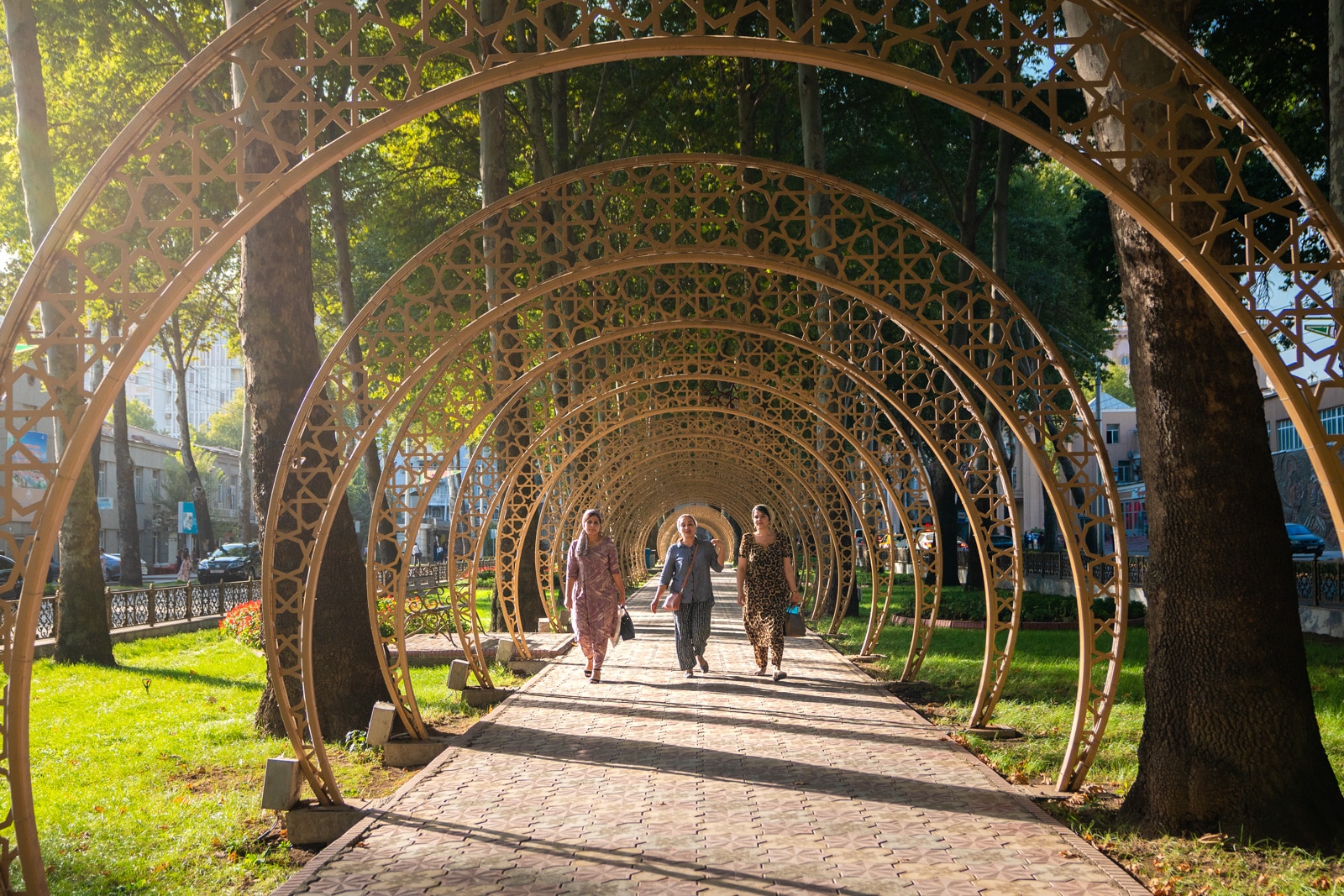 Women walking through a tunnel of arches in Dushanbe, Tajikistan