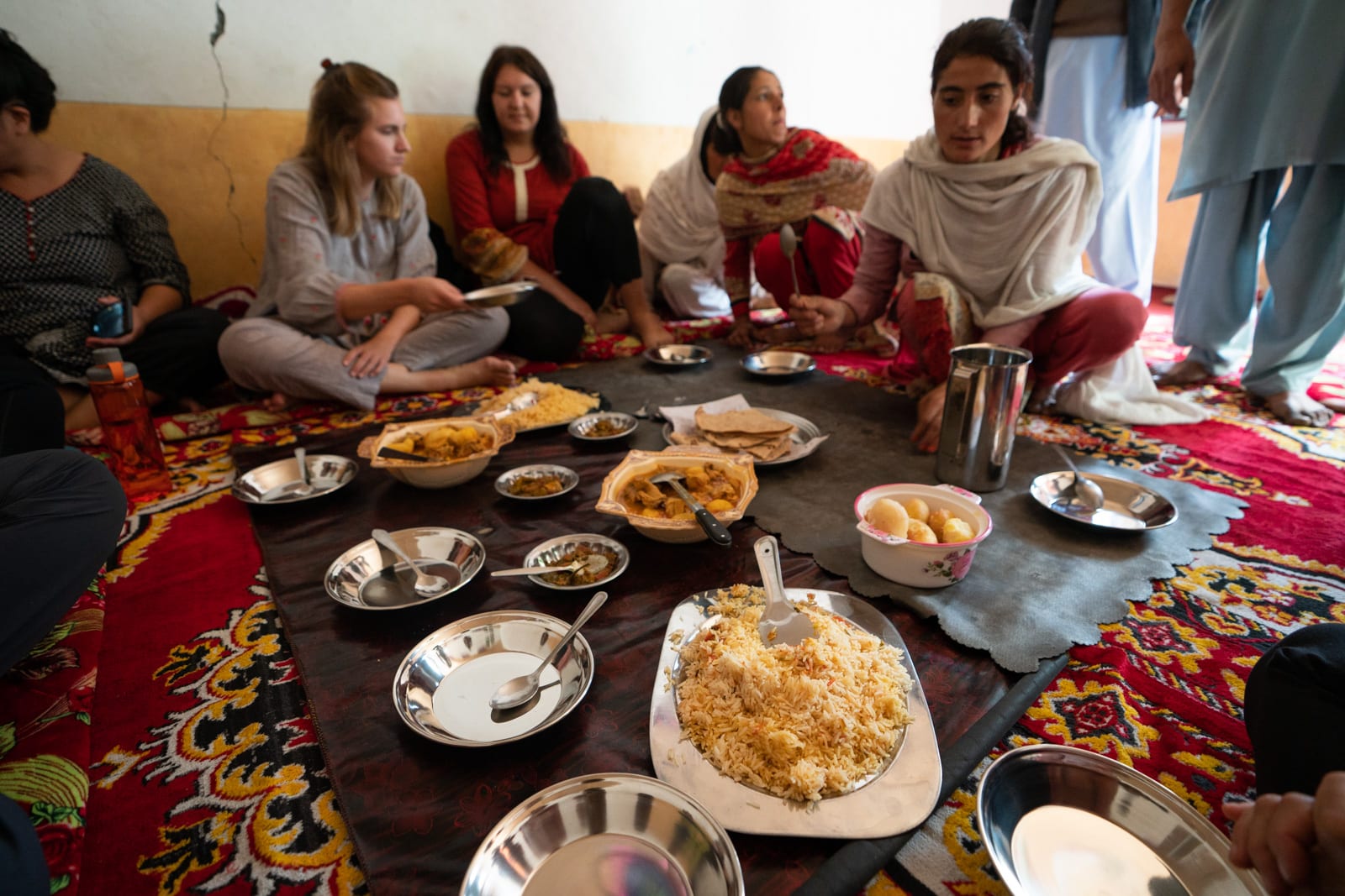 Women sitting on the floor having lunch in Darkot, Pakistan
