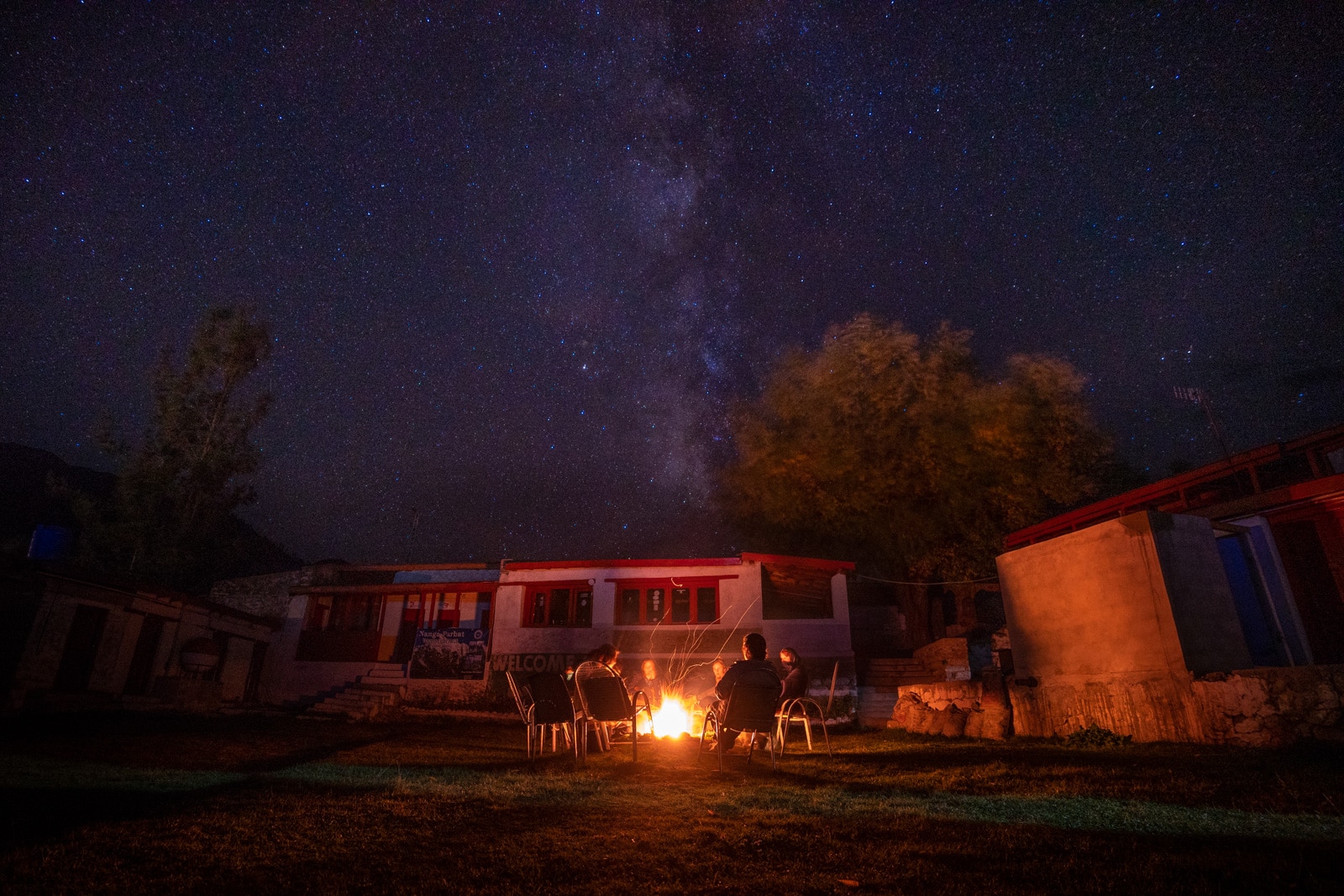 Girls sitting around a campfire under stars in Astore, Pakistan