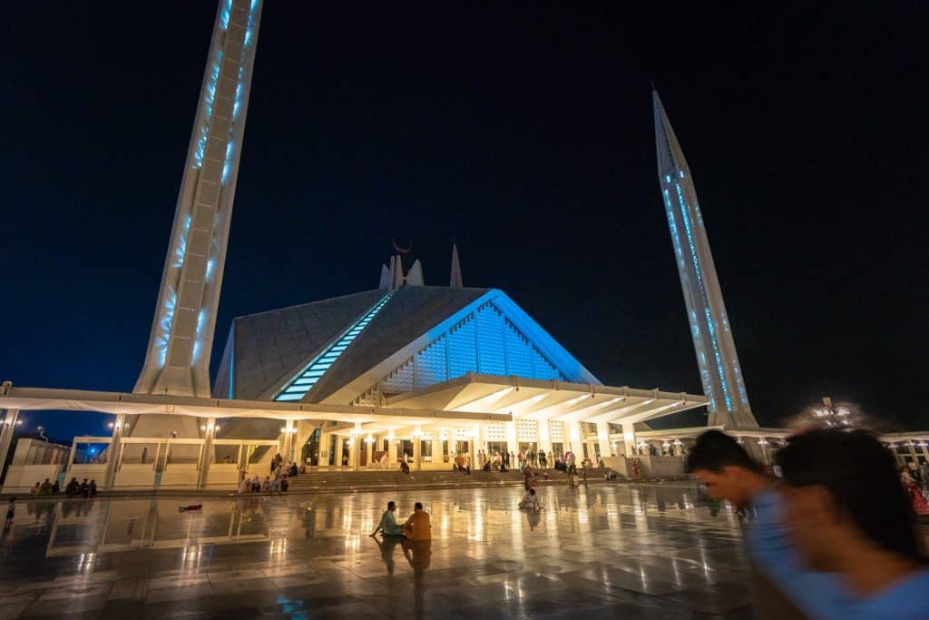 People sitting outside of Faisal Mosque at night in Islamabad, Pakistan