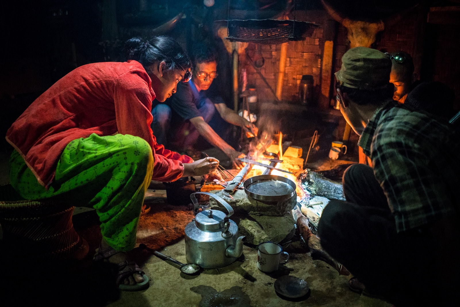 Backpacker cooking opium in Longwa, Nagaland, India with a headlamp