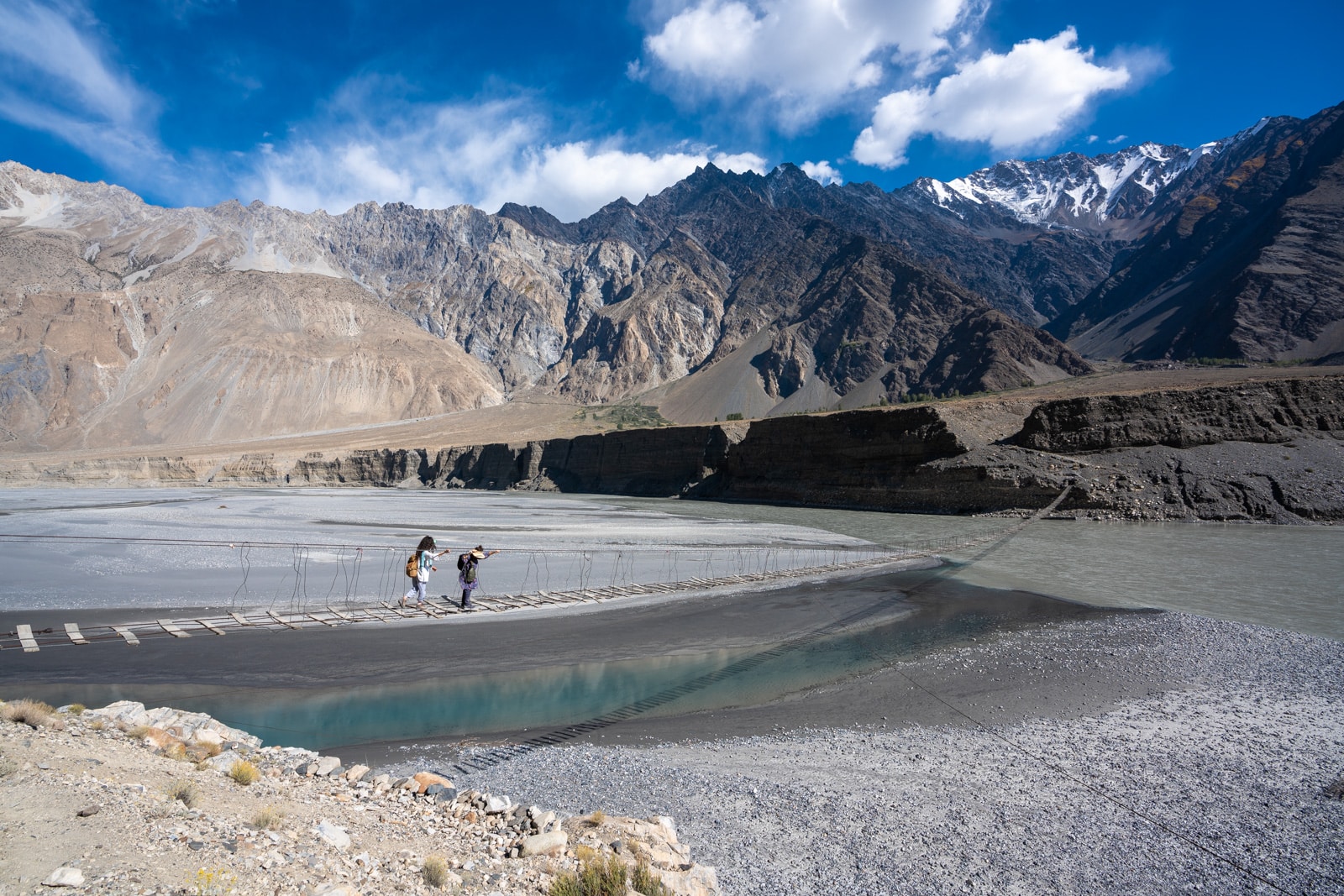 Woman crossing the Passu suspension bridge in Gilgit Baltistan, Pakistan