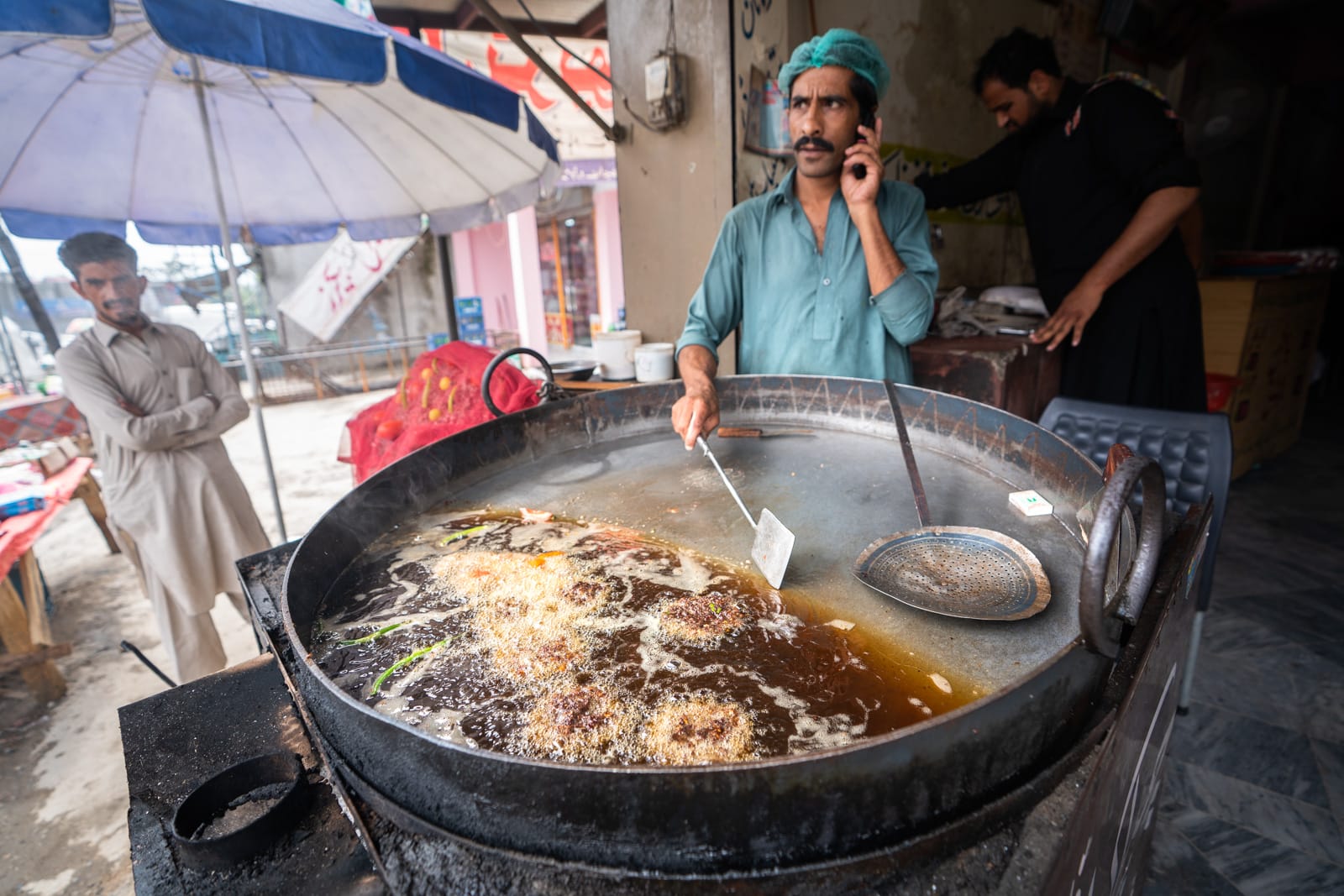 Man cooking chapli kebab in Qalandarabad, Pakistan