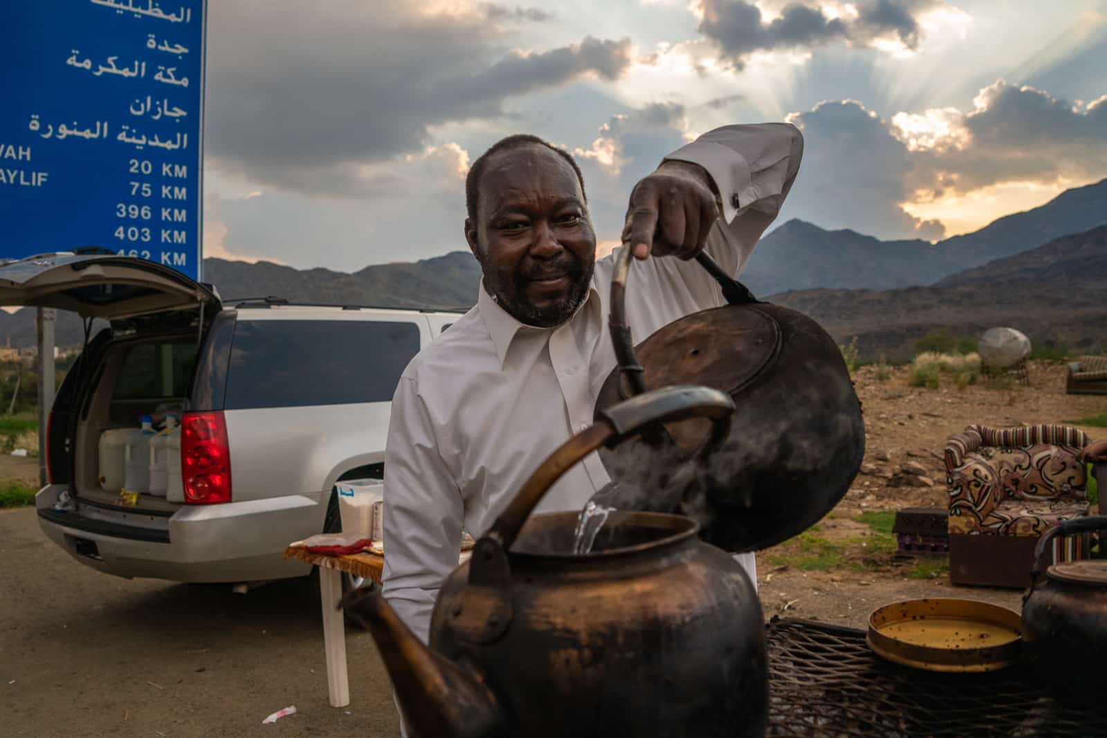 Man pouring hot water for tea on the roadside in Saudi Arabia