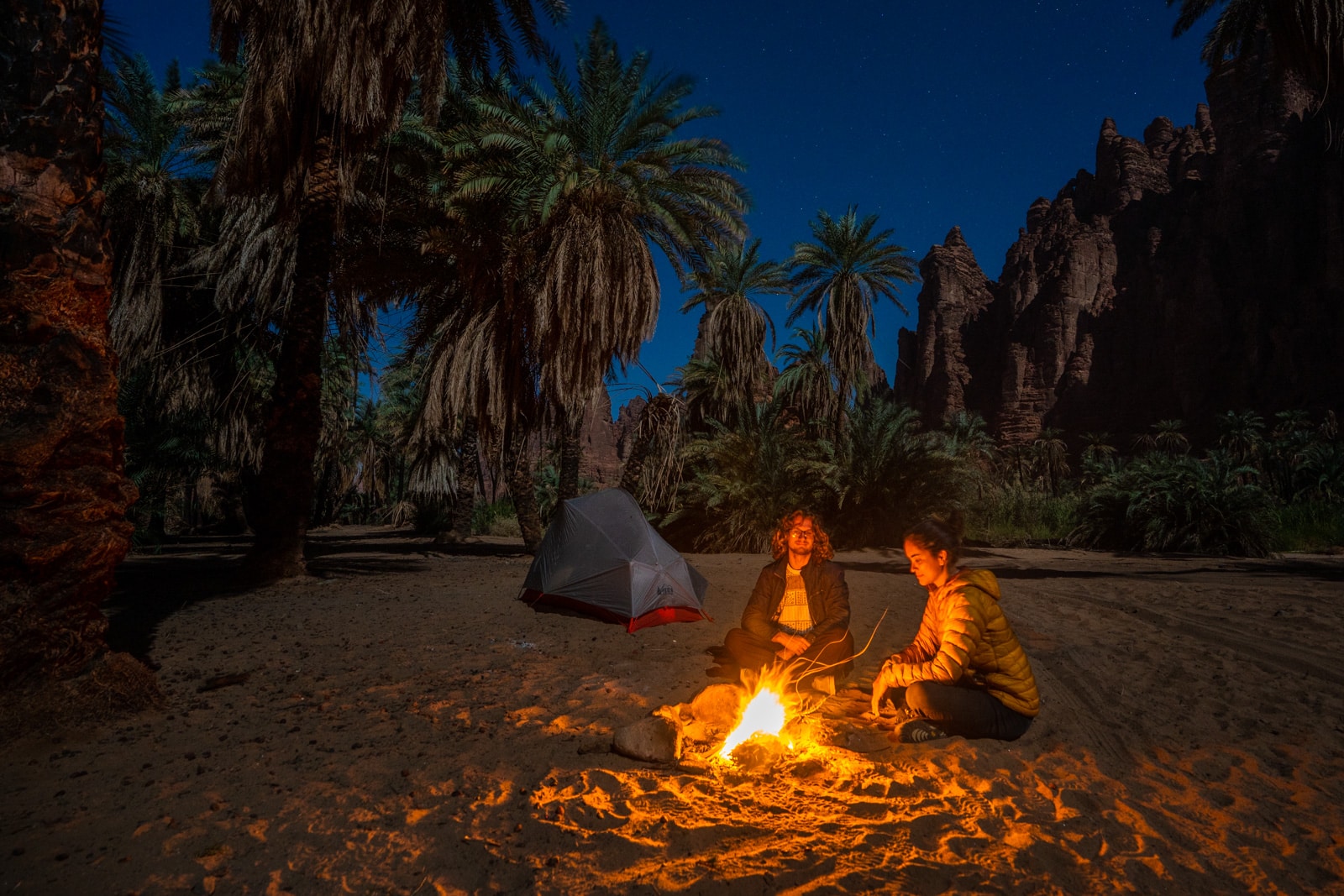 Two travelers at a campfire in Wadi Disah, Saudi Arabia