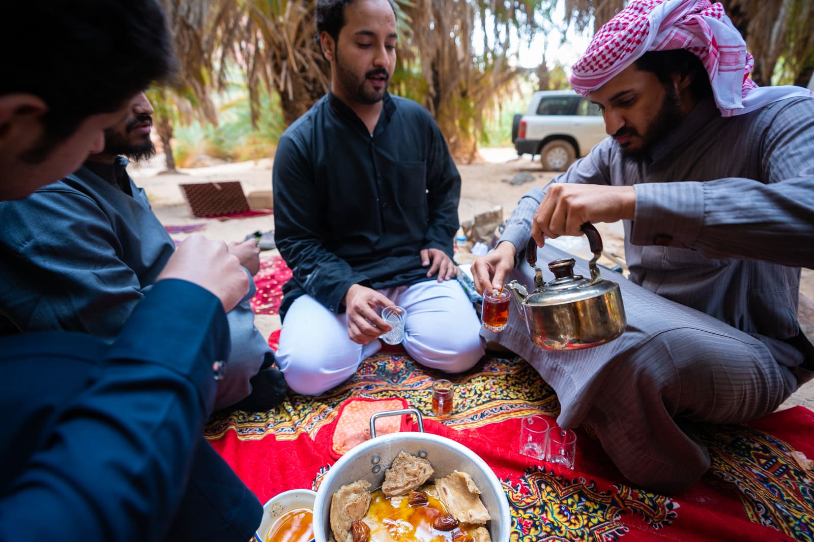 Sitting with men eating lunch in Wadi Disah, Saudi Arabia