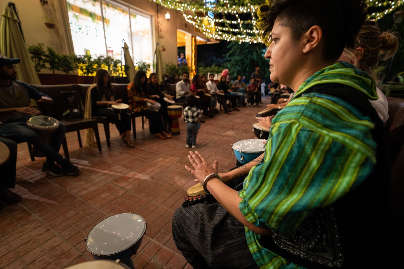 Woman playing in a drum circle in Islamabad, Pakistan