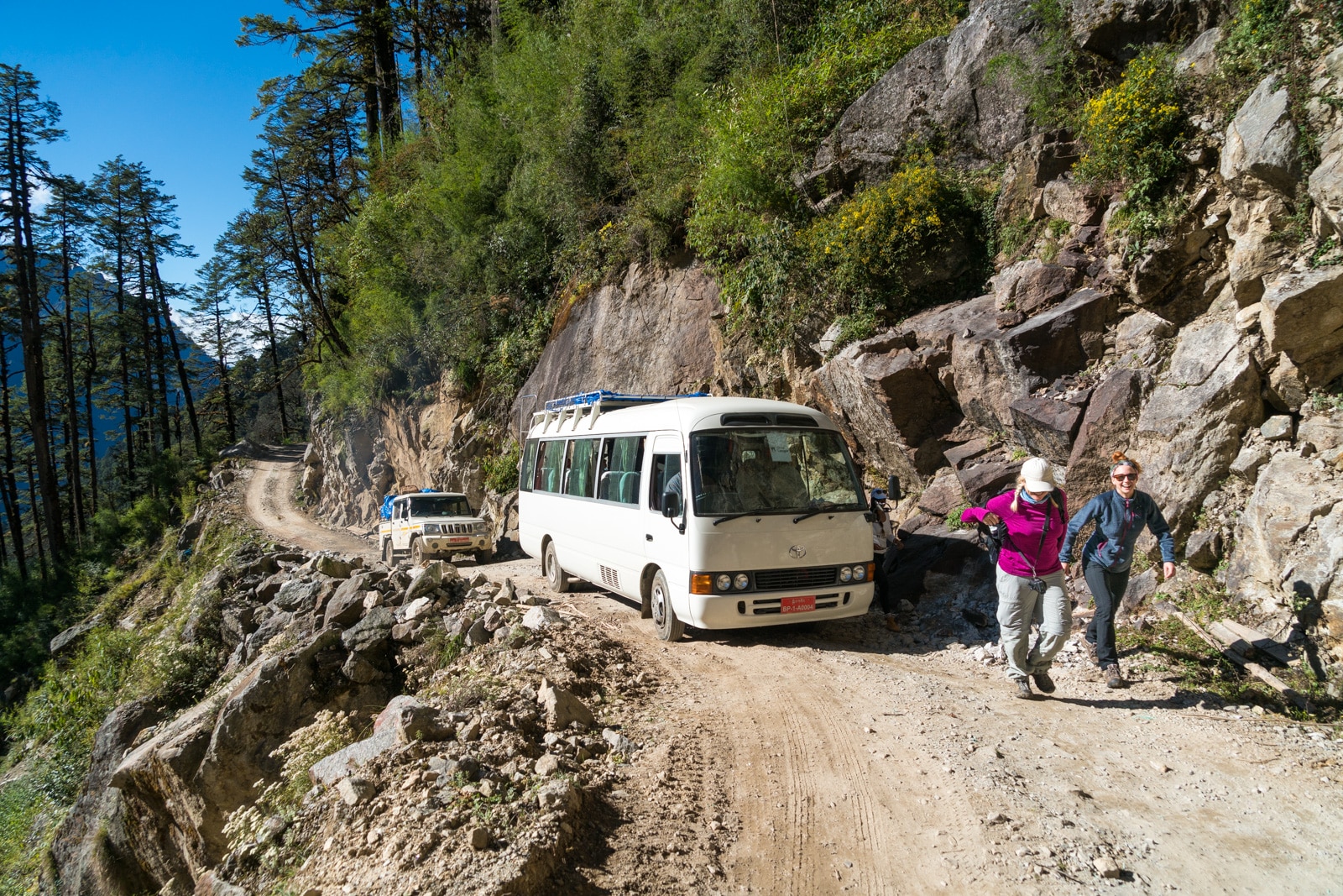 Two foreign tourists walking in front of their tour bus