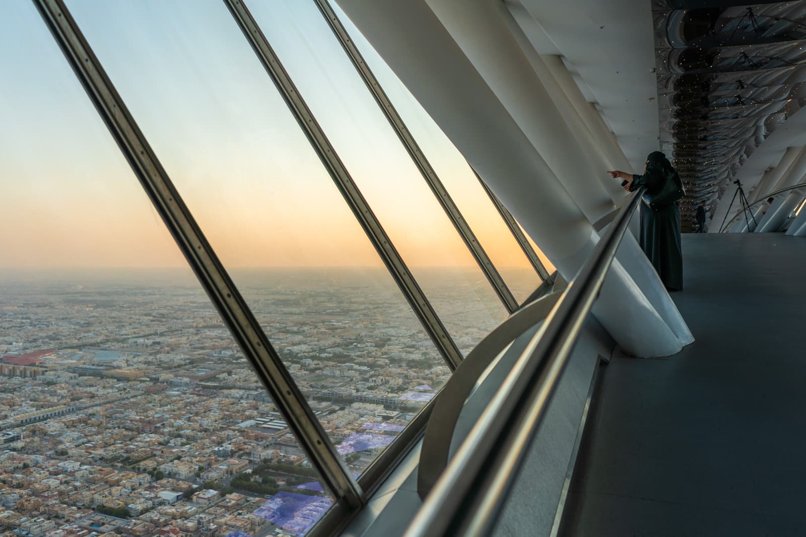 Saudi woman looking at Riyadh skyline from the Kingdom Centre Skybridge