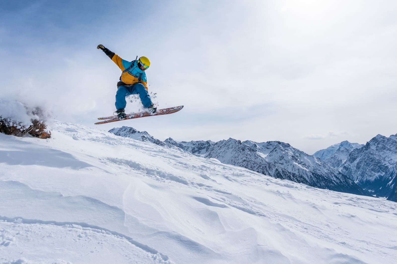 Snowboarder jumping at Karakol ski resort in Kyrgyzstan