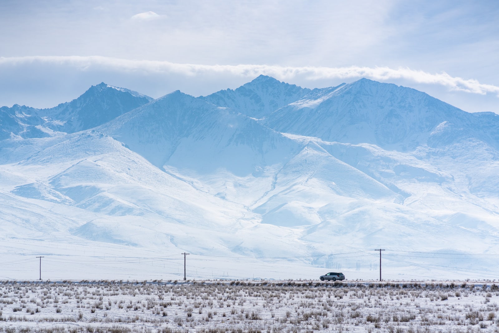 Car driving on the road on the south shore of Lake Issyk Kul, Kyrgyzstan