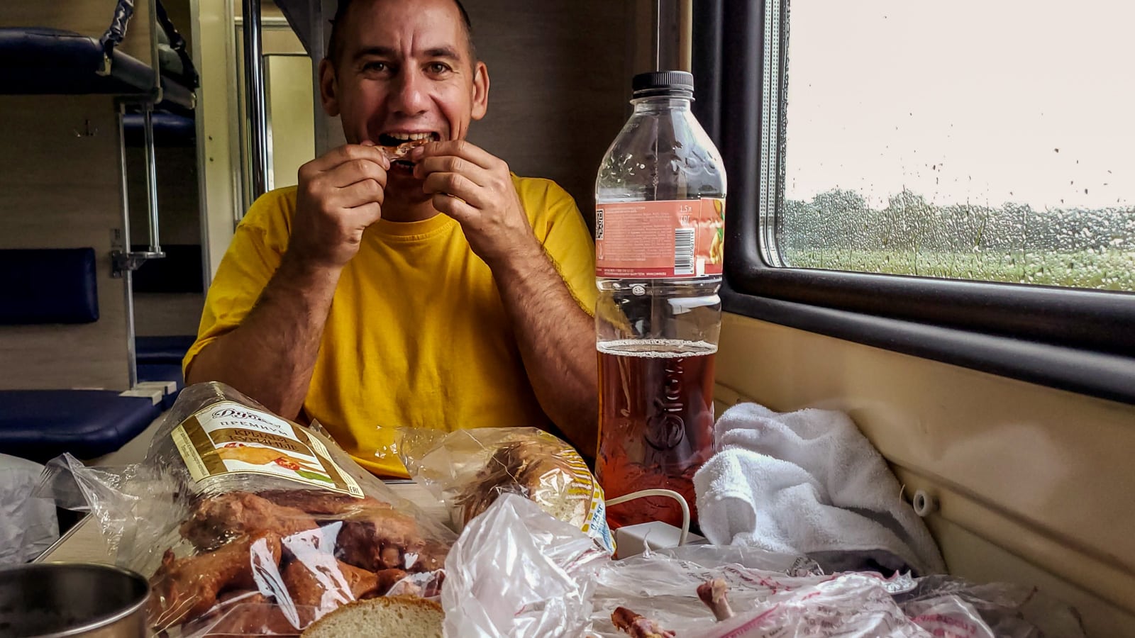 Man eating chicken wings on Russian train