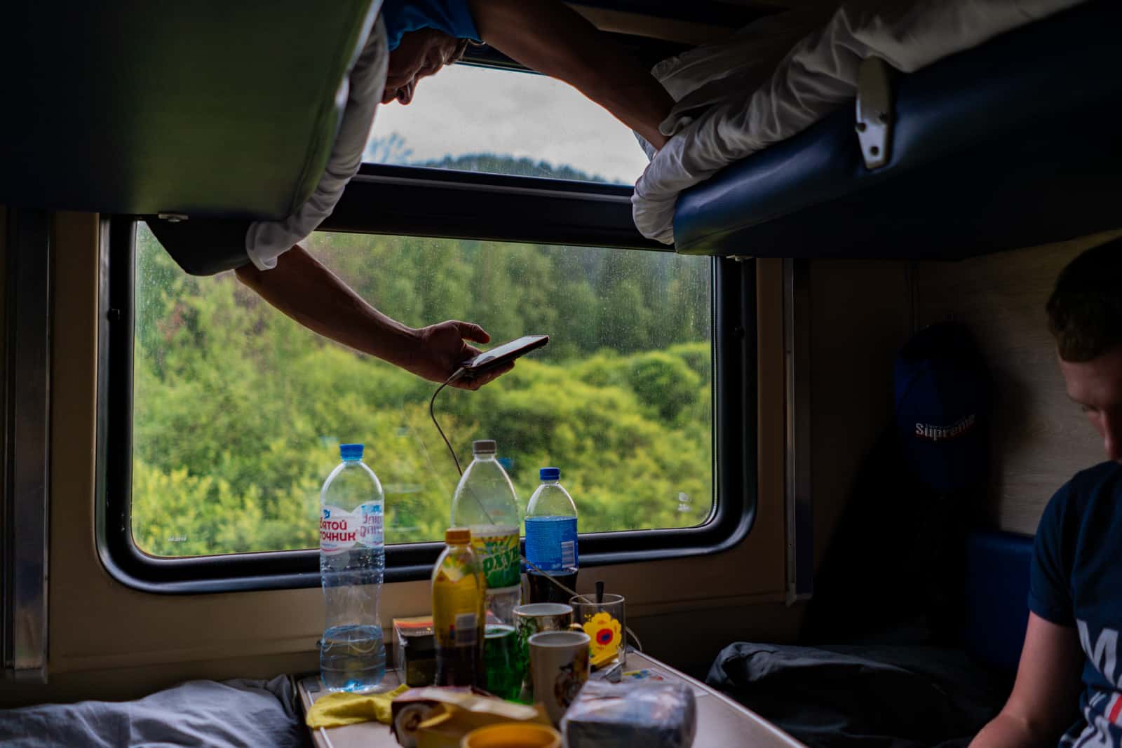 Man using mobile phone charger on Russian train