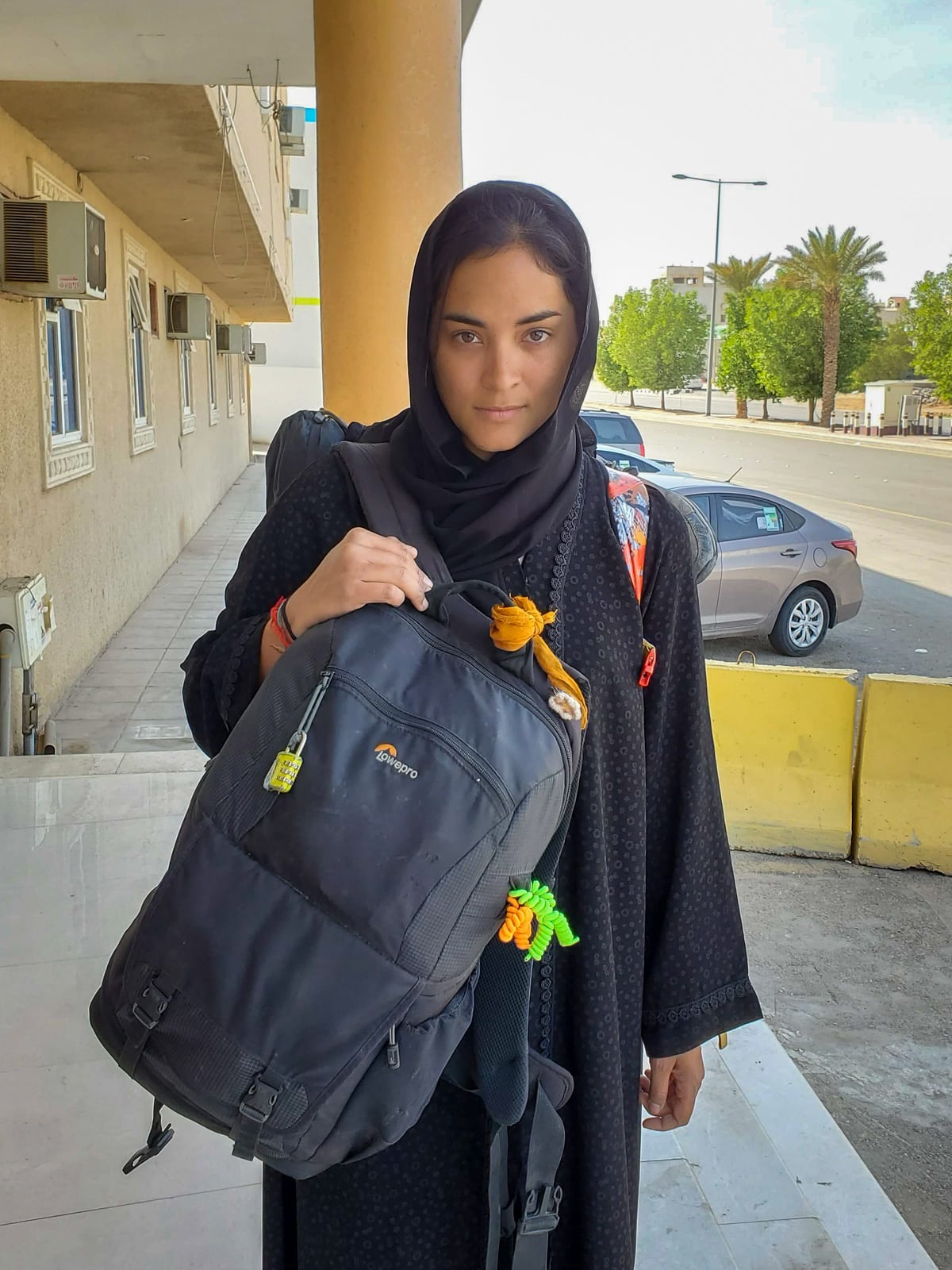 Alex with camera bag and backpack in a black abaya in Riyadh, Saudi Arabia
