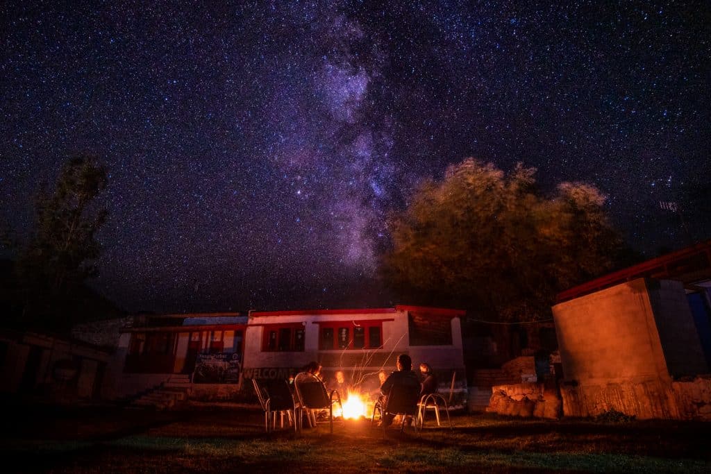 Girls sitting around a campfire under stars in Astore, Pakistan