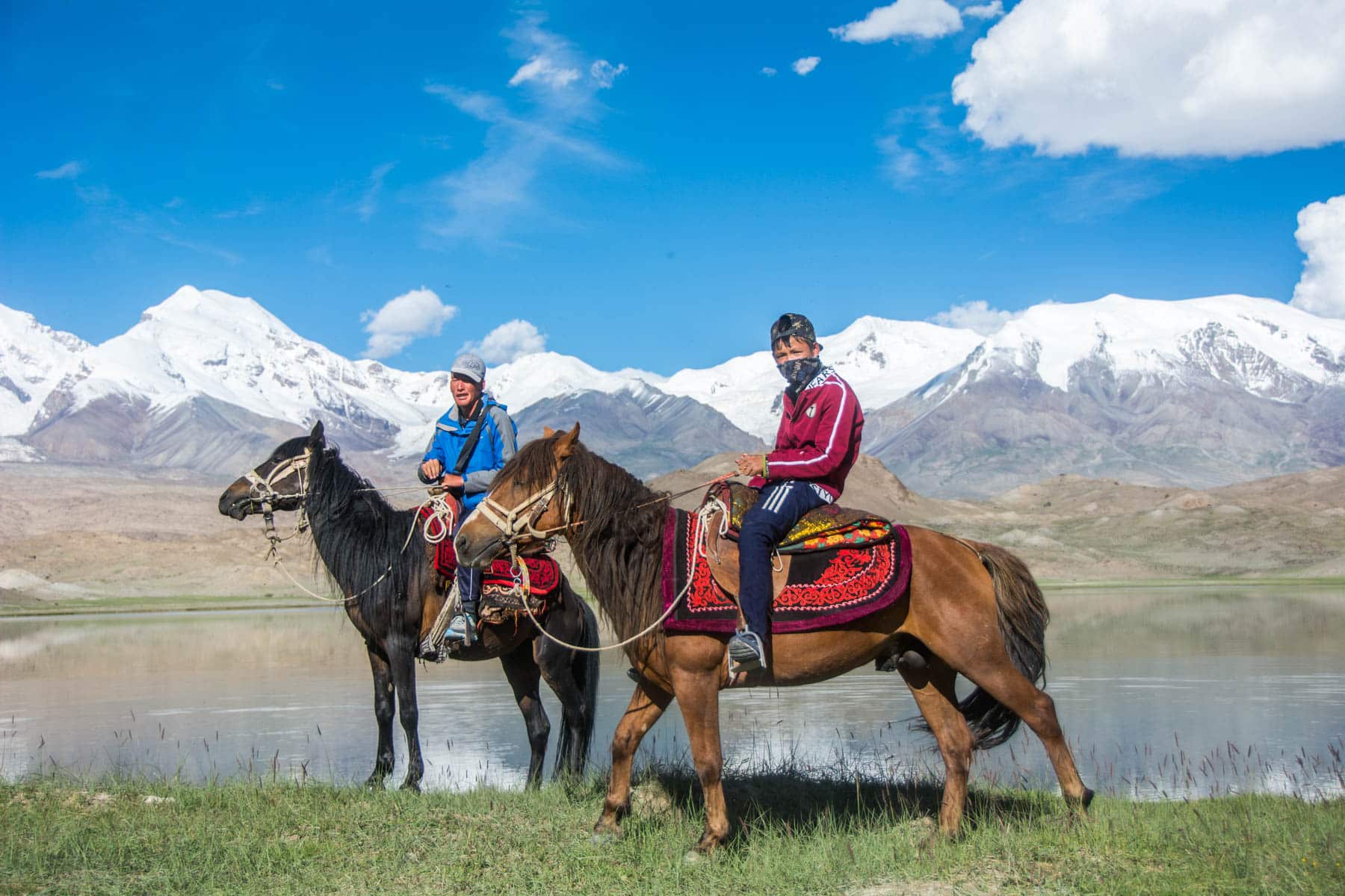 Local Uighur boys on horses at Karakul Lake in Xinjiang, China