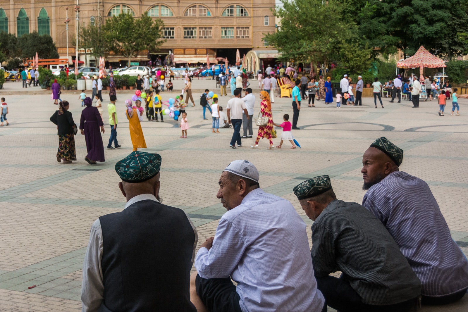 Uighur men sitting in a square in Kashgar, Xinjiang, China