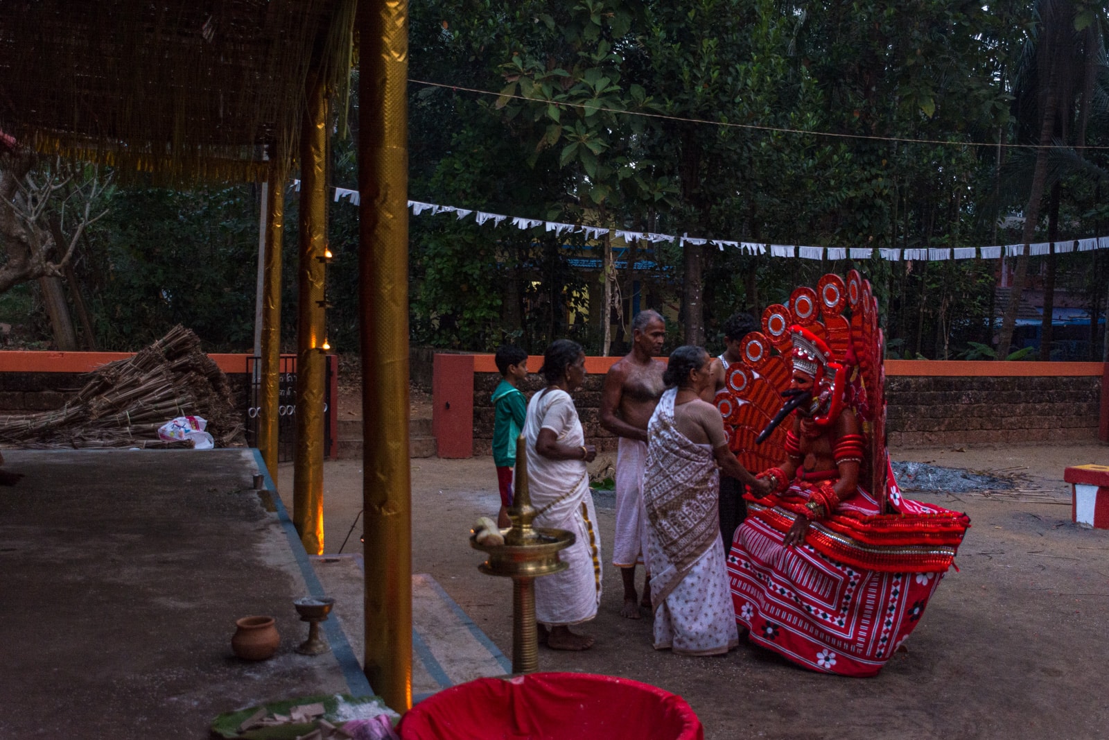 People giving offerings to a theyyam dancer in Kerala, India