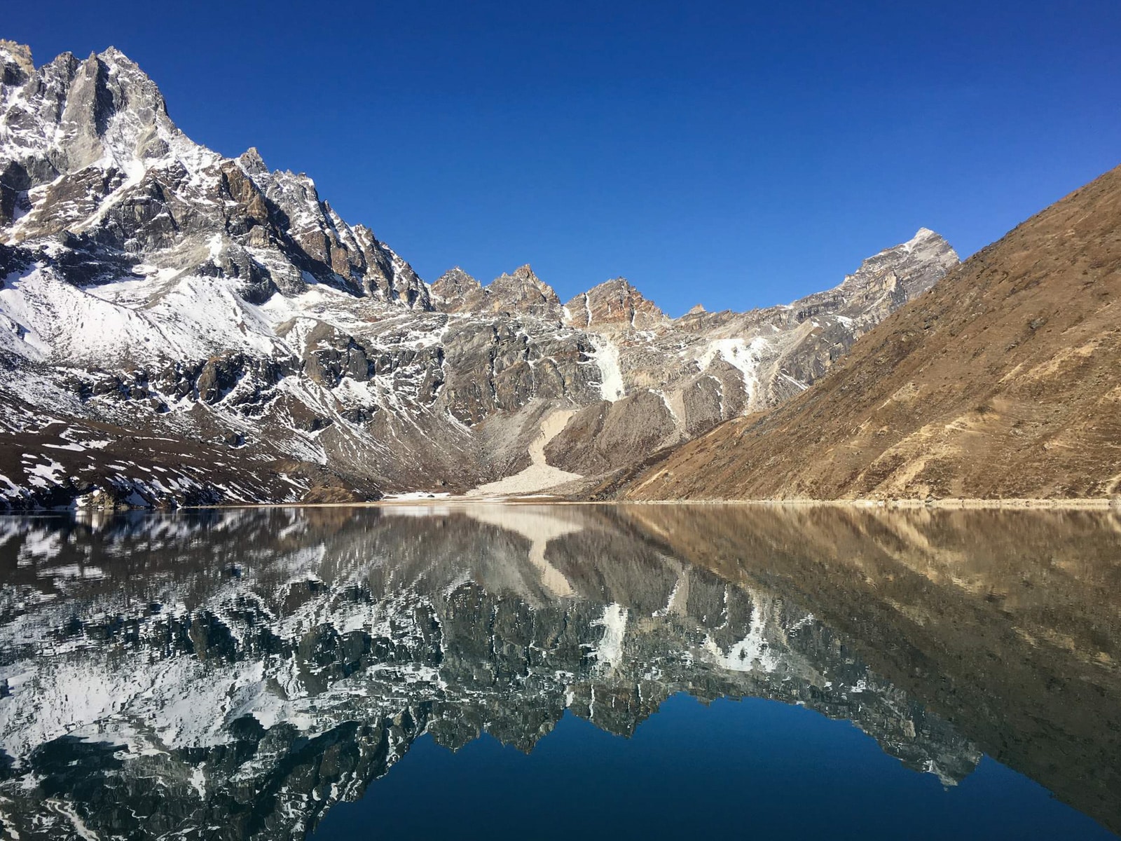 Mountains reflected in Gokyo Lake along the EBC trail in Nepal