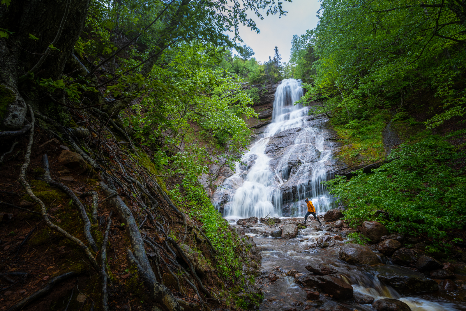 Alex running over rocks at a waterfall in Nova Scotia, Canada