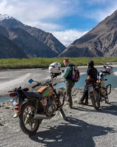 Tour guests on a Pakistan motorcycle tour in Gilgit-Baltistan, on the edge of the Indus Shyok river