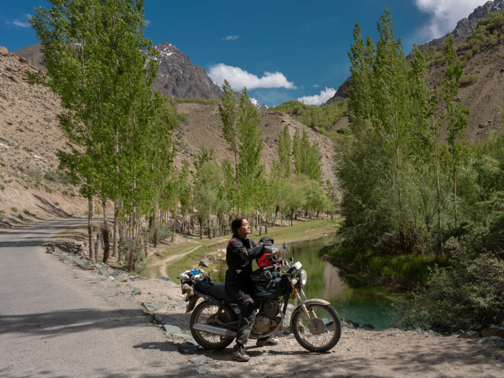 Female biker relaxing in the sun on a Pakistan adventure motorcycle tour