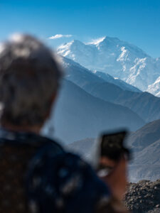 Older female traveler looking at Nanga Parbat on a tour