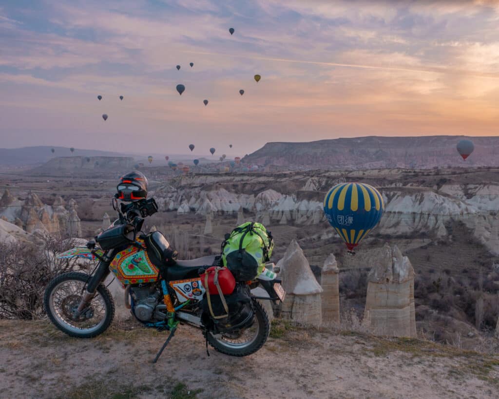 Motorcycle travel in Turkey: sunrise and hot air balloons over a motorcycle in Cappadocia