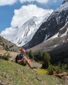 Pakistan 4x4 adventure tour guest relaxing and enjoying the view in Hayol Meadows, Gilgit-Baltistan